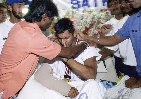India's national hockey team captain Dhanraj Pillay (L) greets tearful injured penalty-corner specialist Jugraj Singh (C), 30 September 2003, at a hospital in New Delhi following India's win against Pakistan in the Asia Cup field hockey final. The team paid tribute and shared their trophy with their injured teammate upon their return from Kuala Lumpur to the Indian capital following their Sunday's 4-2 triumph, after Singh suffered multiple injuries in a car crash.